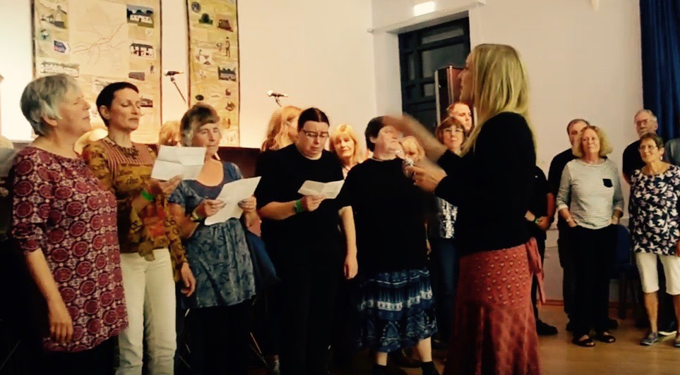A choir singing led by Rowan Godel